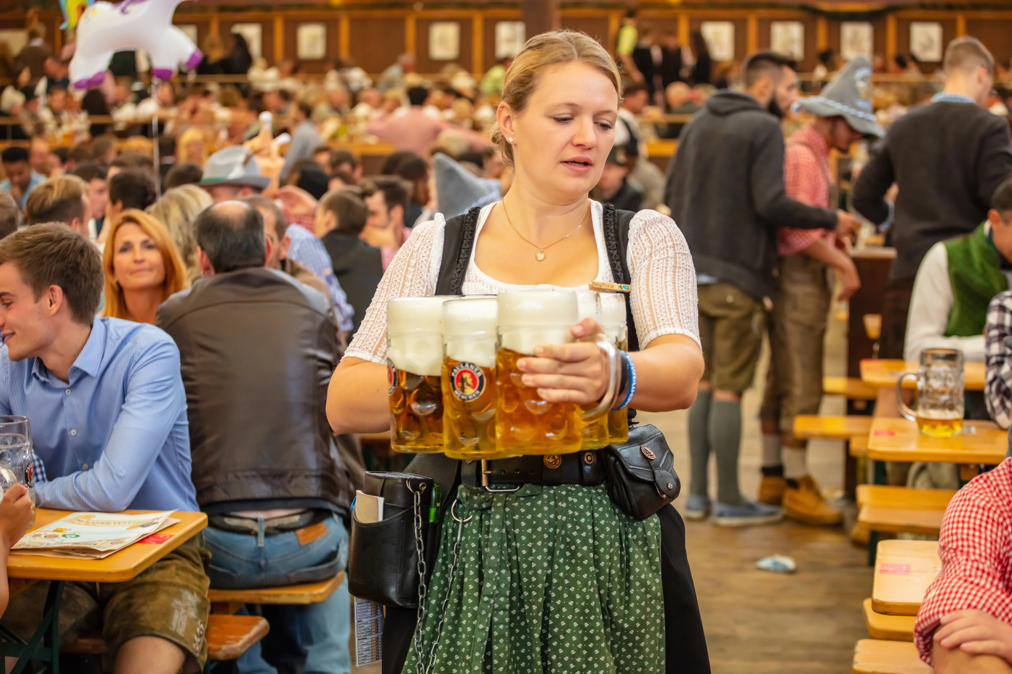 The Ultimate Oktoberfest Travel Guide - Server Carrying a Tray of Beer During Oktoberfest in Germany